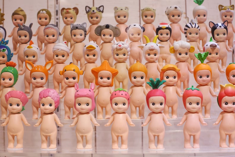 A Sonny Angel doll display featuring plastic baby figurines wearing fruit-themed hats